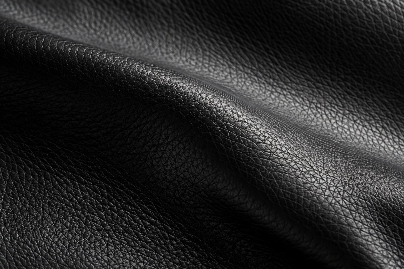 Full-grain black leather with a softly sculpted fold