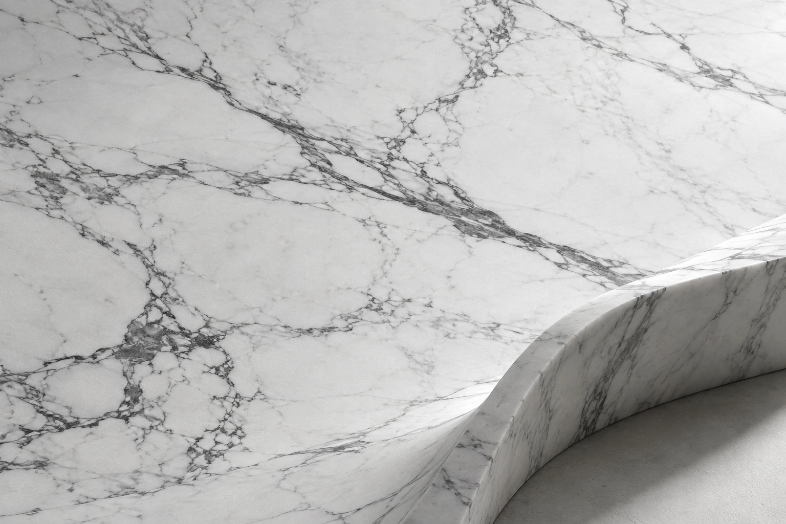 White marble with fine grey veins and a sculptural curved edge